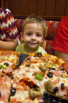 Child Eagerly Awaits Delicious Pizza